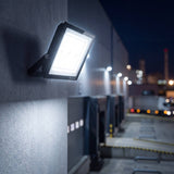 Proyector exterior LED de alta potencia iluminando zona de carga industrial nocturna.