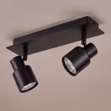 Plafón rectangular con dos puntos de luz direccionables en aluminio negro para iluminación técnica.