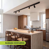 Riel magnético adosable con spots iluminando una cocina con isla de diseño minimalista