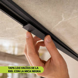 Mano insertando mica negra mate para tapar tramos vacíos del riel magnético