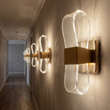 Serie de lamparas de pared Flow Gold instaladas de forma vertical en un pasillo largo.