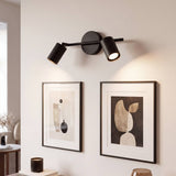 Spot doble iluminando cuadros enmarcados en la pared