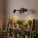 Spot doble iluminando rincón con plantas y luz cálida