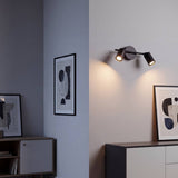 Spot doble iluminando el dormitorio junto al cuadro de la pared