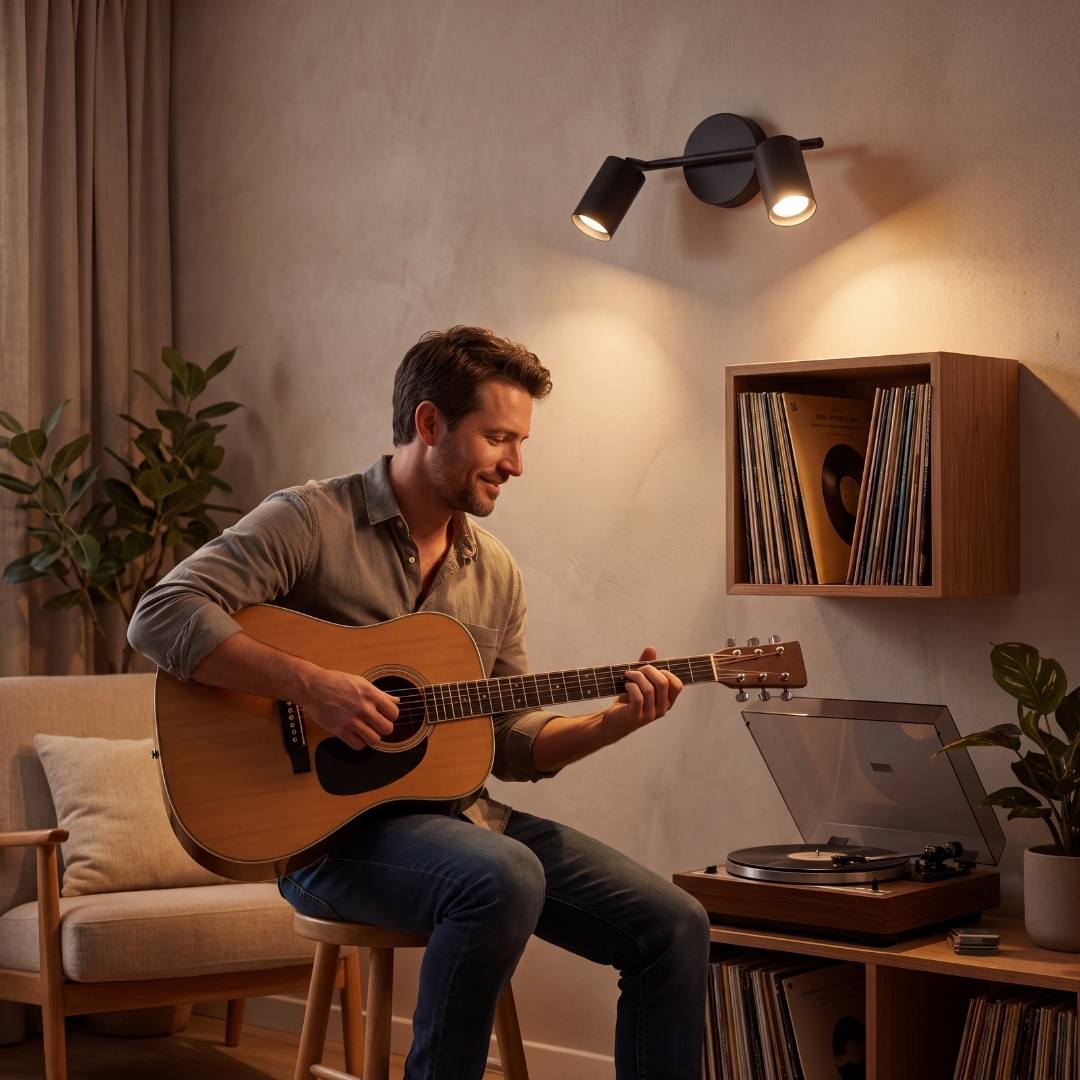 Spot doble iluminando a hombre tocando guitarra junto a su laptop
