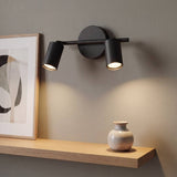 Spot adosable doble negro con dos cabezales iluminando cuadro y repisa