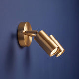 Spot dorado como aplique de pared con cabezal dirigido en pared azul