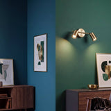 Spot doble dorado iluminando cuadros sobre pared verde
