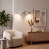 Spot doble blanco iluminando el rincón del sillón con luz cálida