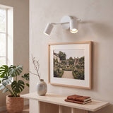 Spot doble iluminando cuadro enmarcado sobre panel de madera
