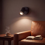 Spot dirigible negro iluminando el dormitorio con luz cálida