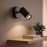 Spot adosable negro con anillo difusor encendido iluminando la repisa