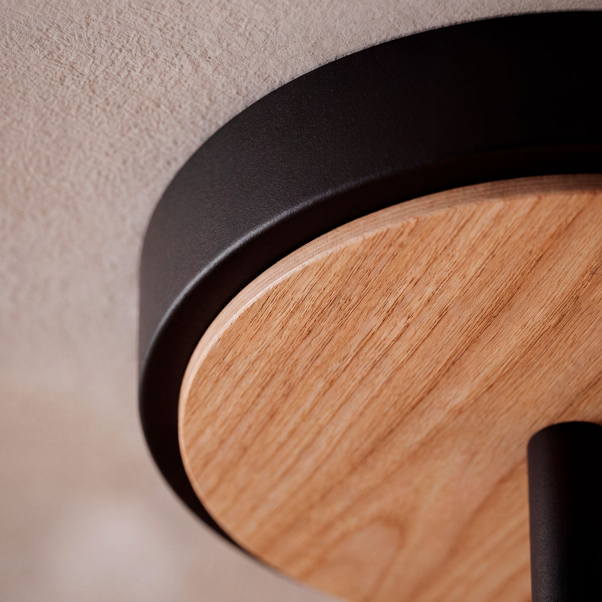 Detalle del disco de madera natural integrado en la base negra