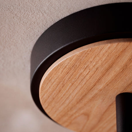 Detalle del disco de madera natural integrado en la base negra