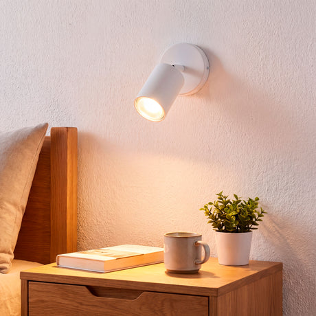 Spot adosable blanco dirigiendo luz cálida sobre el escritorio de madera