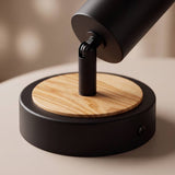 Detalle del disco de madera natural bajo la base negra del spot