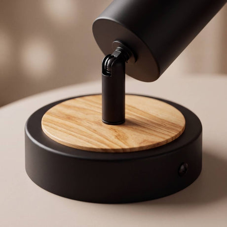 Detalle del disco de madera natural bajo la base negra del spot