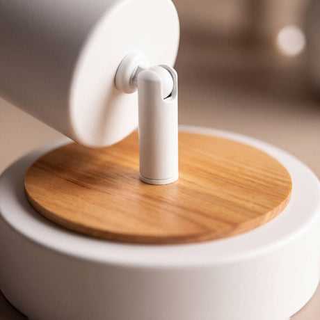 Detalle del disco de madera natural bajo la base blanca del spot