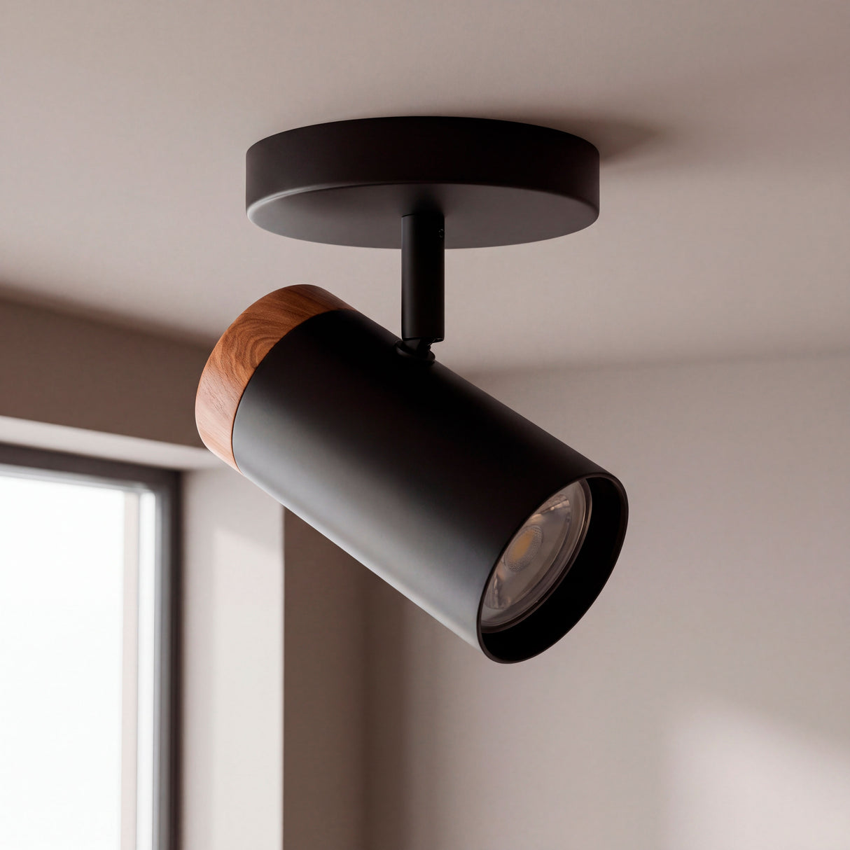 Spot adosable negro con remate de madera y cabezal dirigible en el techo