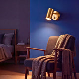 Spot dorado encendido junto al sillón del rincón de lectura de noche