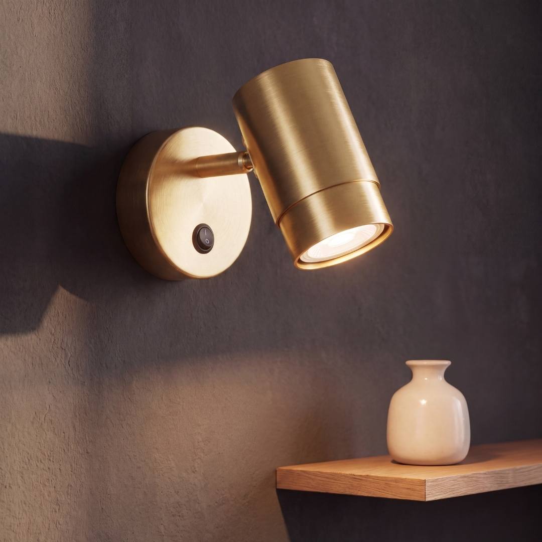 Spot adosable dorado satinado con cabezal girable encendido en la pared