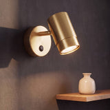 Spot adosable dorado satinado con cabezal girable encendido en la pared