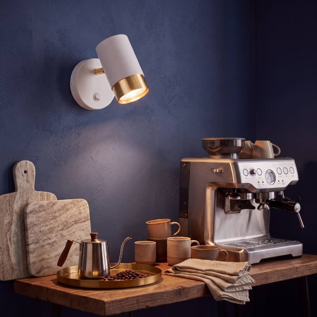 Spot blanco y dorado iluminando el rincón de café con luz cálida
