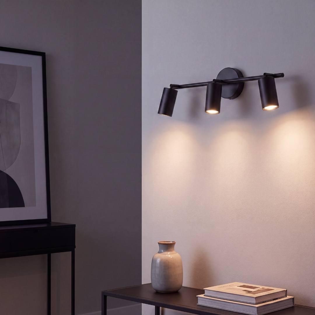 Spot triple iluminando la cabecera del dormitorio con luz cálida