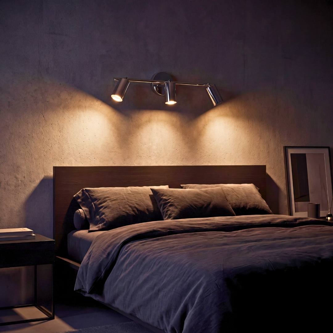 Spot triple iluminando la cabecera del dormitorio con luz cálida