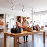 Amigas en una boutique de carteras iluminada con spots de riel ROXY White