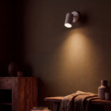 Spot blanco como aplique dirigible proyectando luz en pared oscura