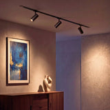 Spot de riel iluminando un cuadro en la pared como galería