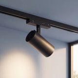 Spot LED de riel encendido proyectando su haz de luz cálida