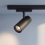 Spot LED negro de riel con cabezal girable proyectando luz en el techo