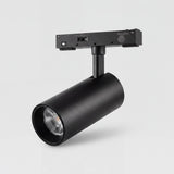 Spot LED negro montado en adaptador de riel sobre fondo claro