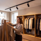 Spots LED de riel iluminando prendas en tienda de ropa