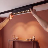 Spot LED magnético creando ambiente cálido acogedor en sala moderna