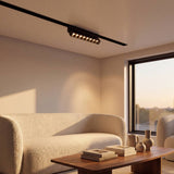 Spot LED magnético articulable en riel iluminando sala moderna