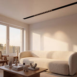 Spot LED magnético en riel de techo iluminando sala de estilo minimalista