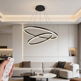 Luminaria de suspensión con tres anillos entrelazados sobre mobiliario de diseño minimalista y tonos claros.