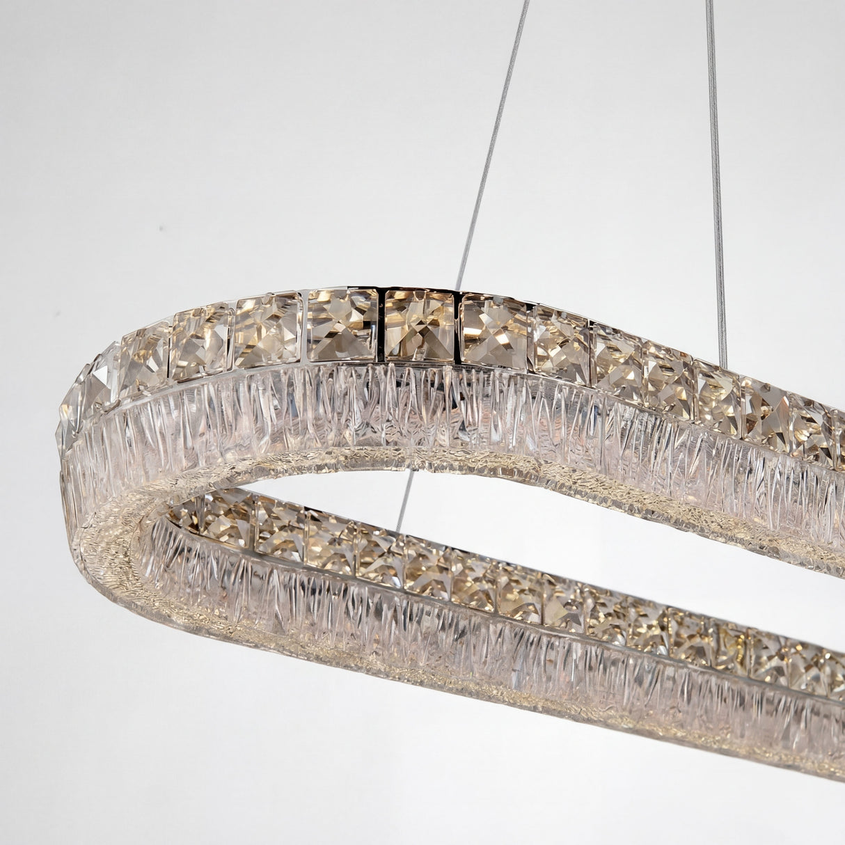 Detalle de cristales facetados y estructura de acero cromado para reflexión de luz premium.
