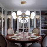 Walk-in closet moderno con luz neutra y la lampara Collier Gold reflejada en los espejos del armario.